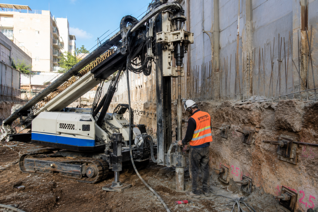 קידוח כלונסאות מיקרופייל באתר בנייה באמצעות מכונת קידוח מתקדמת לחיזוק יסודות וביסוס מבנים בקרקע מורכבת.
